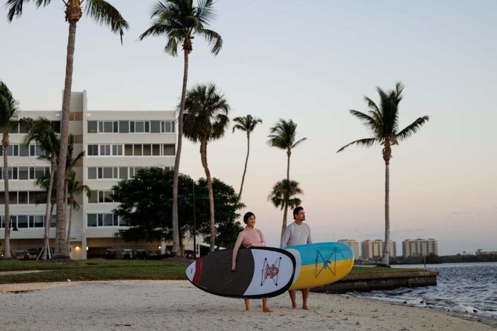 A couple going to surf on a beach in Fort Myers, FL